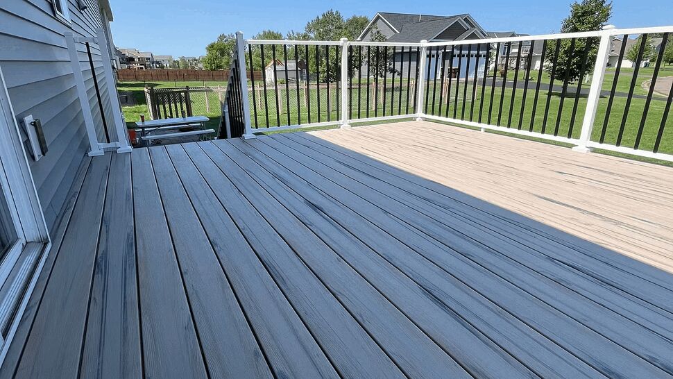 Wide view of gray deck surface and black baluster railing