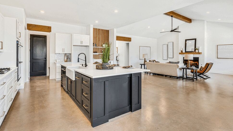 Bright open-concept kitchen with large dark island and adjoining living area