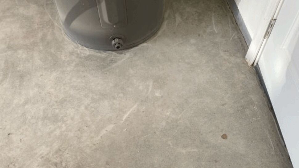 Bare concrete floor under a water heater prior to coating.