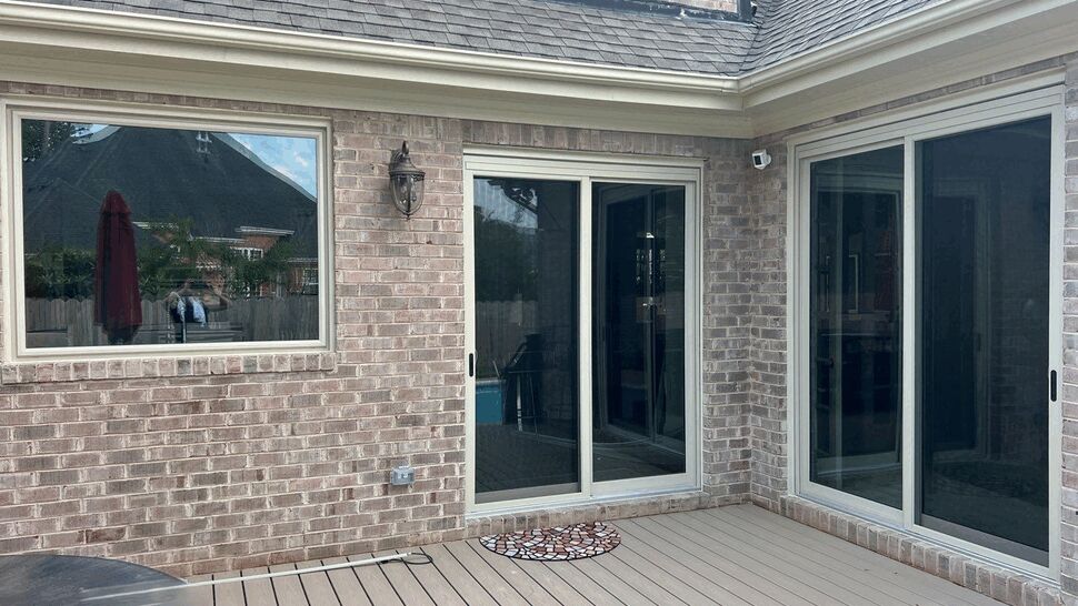 Brick patio with sliding glass doors and large window