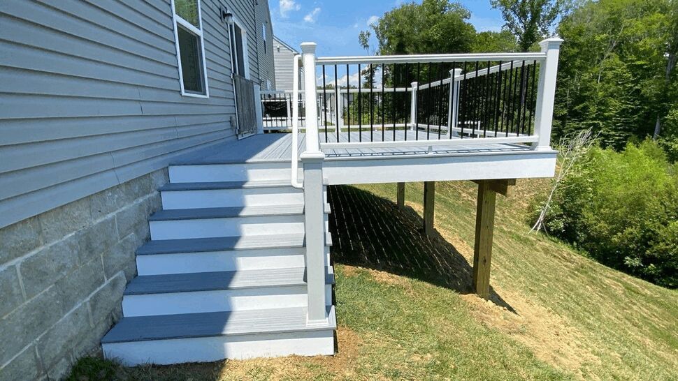 Gray composite deck steps with white posts and black round balusters