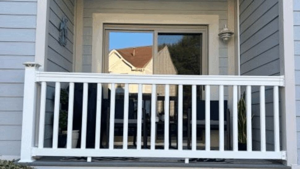 Covered front porch with white railing and blue siding