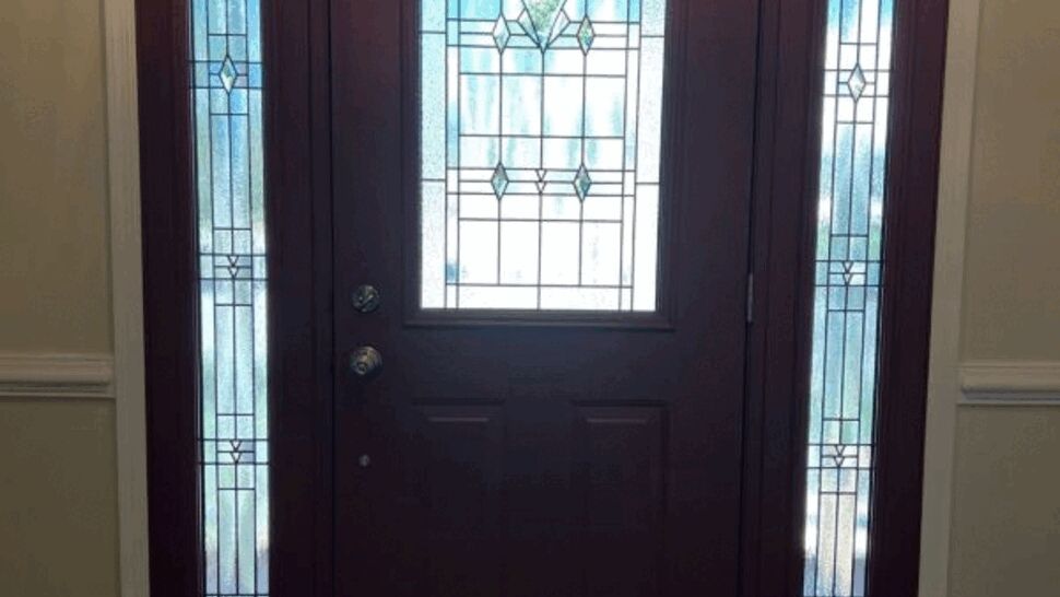 Dark entry door with decorative glass and full-height sidelights