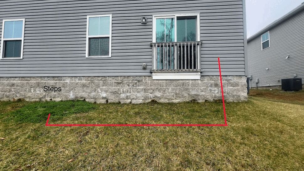 House wall with red outline marking proposed deck and steps area on lawn
