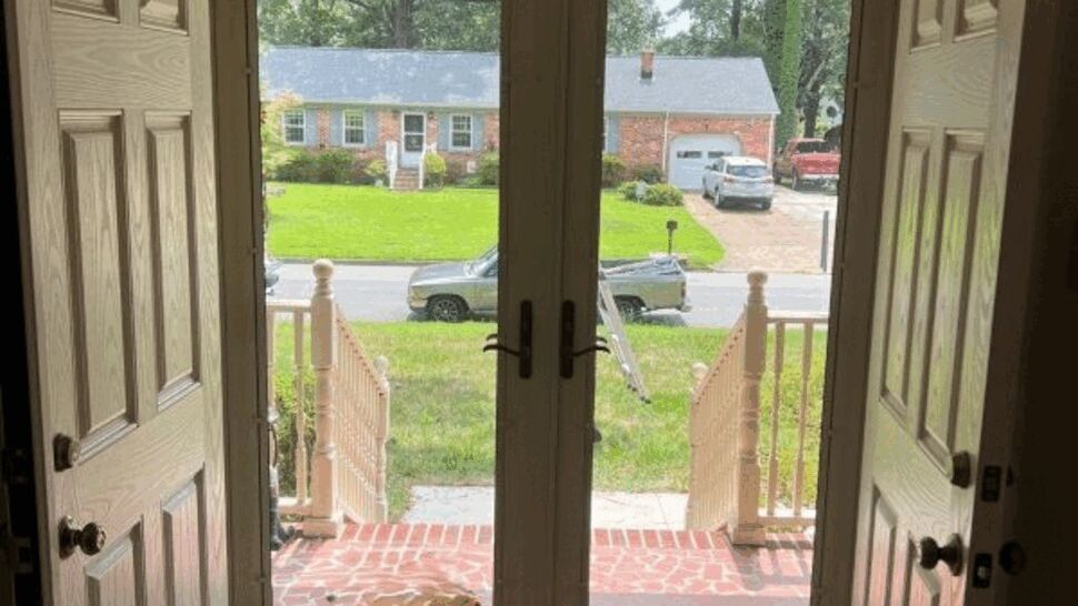 Interior view looking out through glass double entry doors to front steps and street