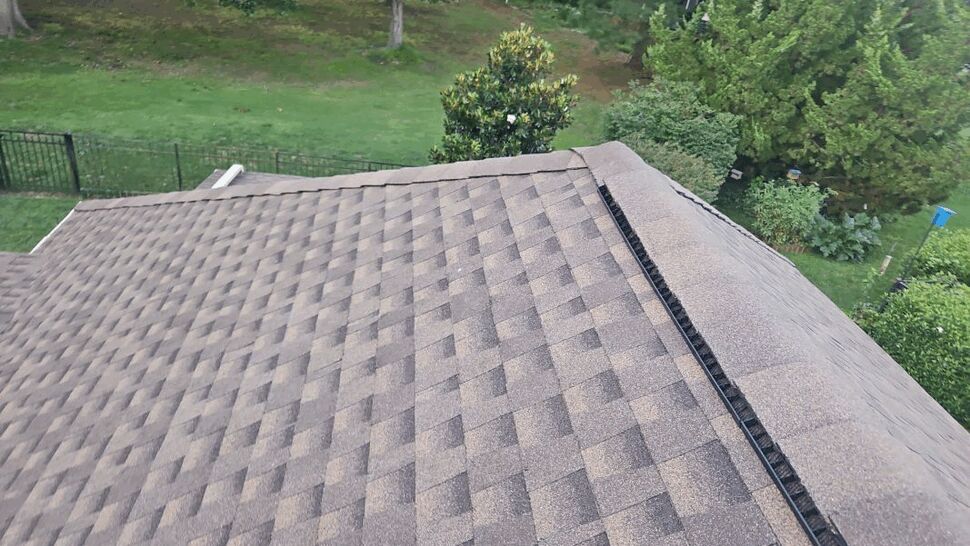 Ridge Vent Close-up Timberline Shingles | Exterior Source Virginia Close-up of brown Timberline shingles and black ridge vent on roof peak