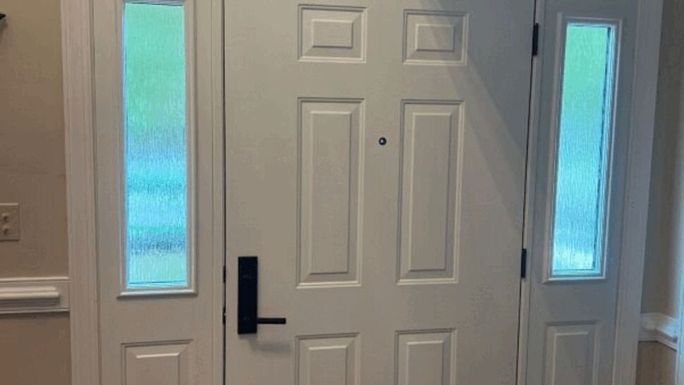 White front door with two narrow sidelights and modern black handle