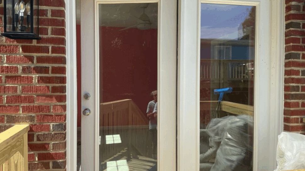White double entry doors with large glass panels on a brick home