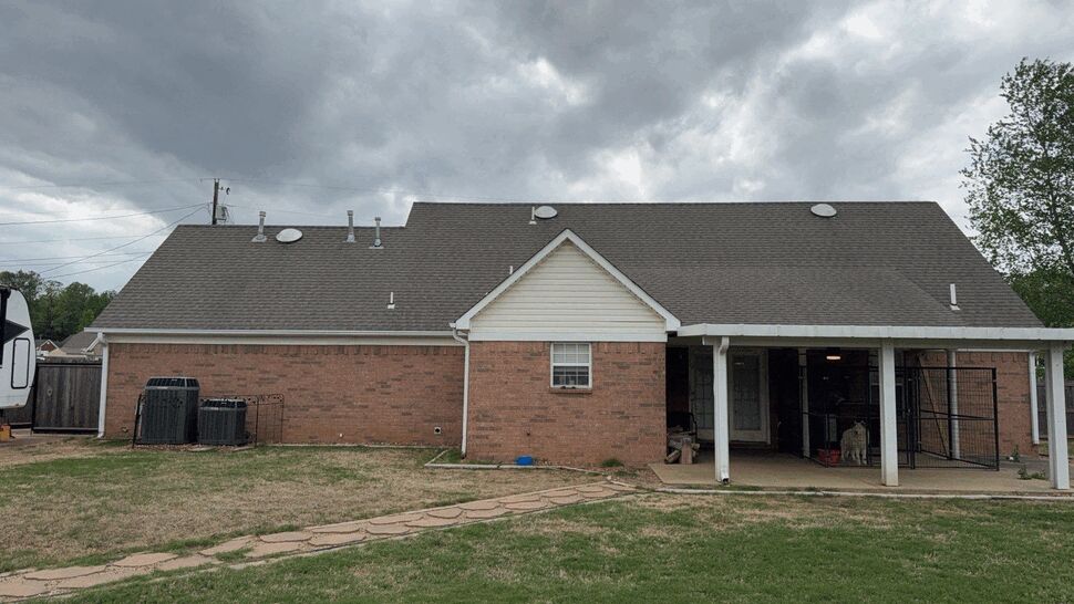Back of brick house showing roofline, gutters and HVAC units