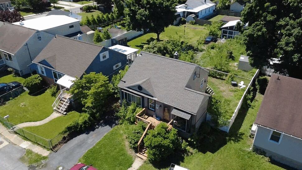 Aerial Home Deck Overview | Wells Home Improvements Aerial view of a house with a wooden front deck and shingled roof