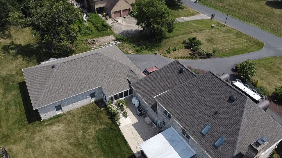 Top-down view of house roof, driveway, and gutter lines