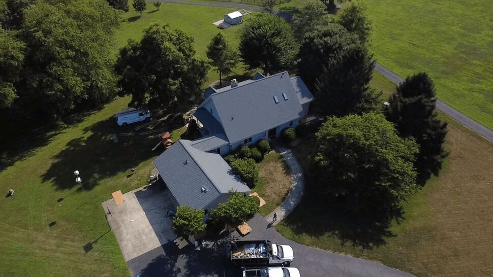 Aerial Roofing Worksite | Wells Home Improvements Aerial view of house roof with trucks, dumpster and crew on site.