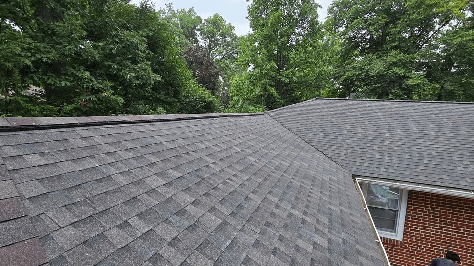 Asphalt Shingle Roof Detail | Wells Home Improvements Close-up of gray asphalt shingles and ridge vent on sloped roof