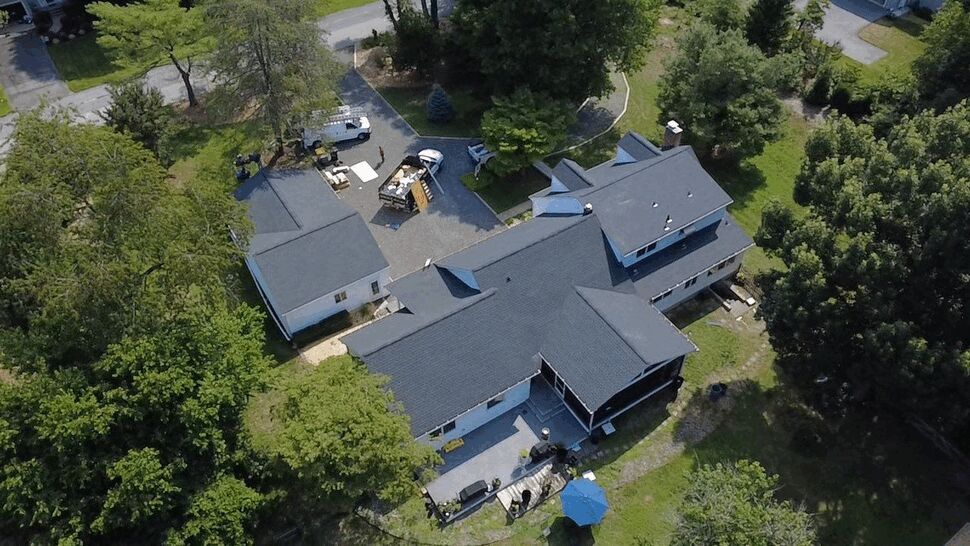 Backyard Deck and Roof Overview | Wells Home Improvements Overhead view of a backyard deck, patio umbrella, and adjacent roofline