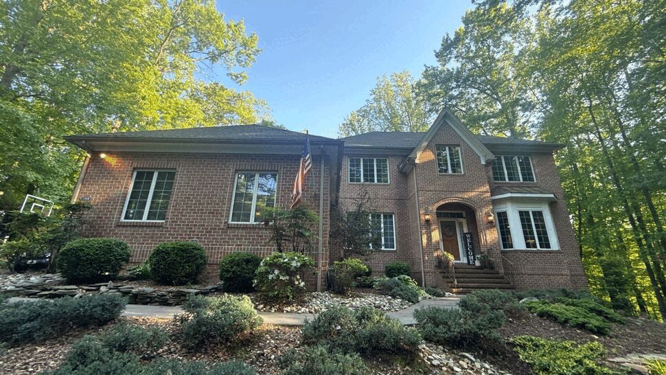Brick Home Front Exterior | Wells Home Improvements Two-story brick home with dark roof, white windows, and landscaped front yard.