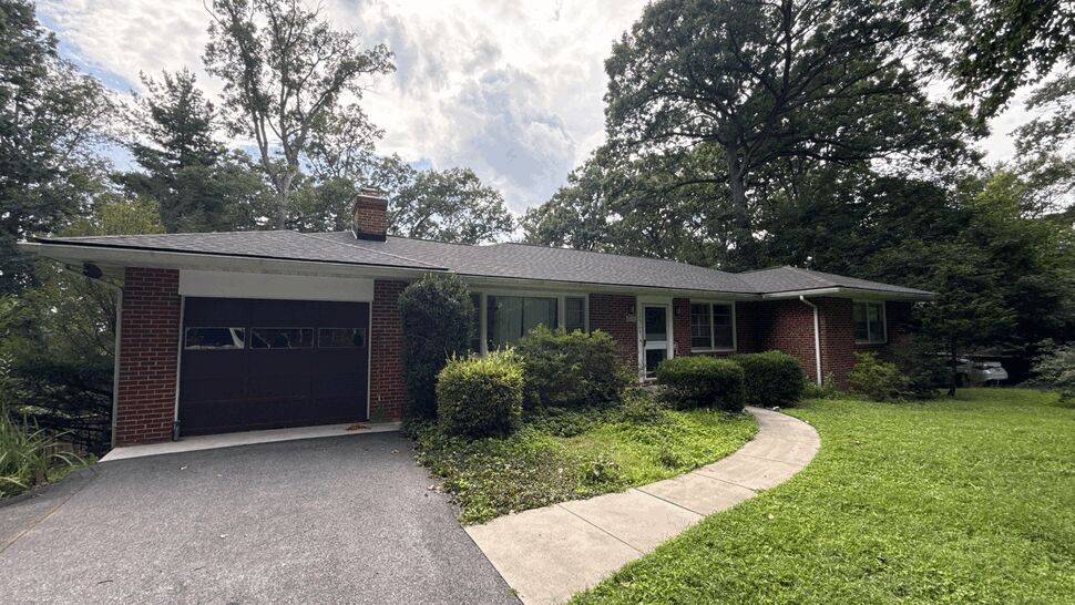 Front View of Brick Ranch Roof | Wells Home Improvements Single-story brick ranch home with asphalt shingle roof and driveway