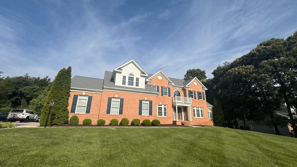 Front elevation of a brick colonial home with new shingles