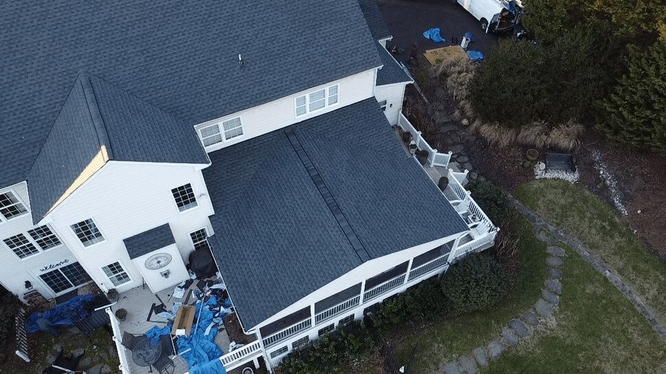 Covered Porch Roof and Deck | Wells Home Improvements Close aerial of covered porch roof and adjacent deck with white railings.