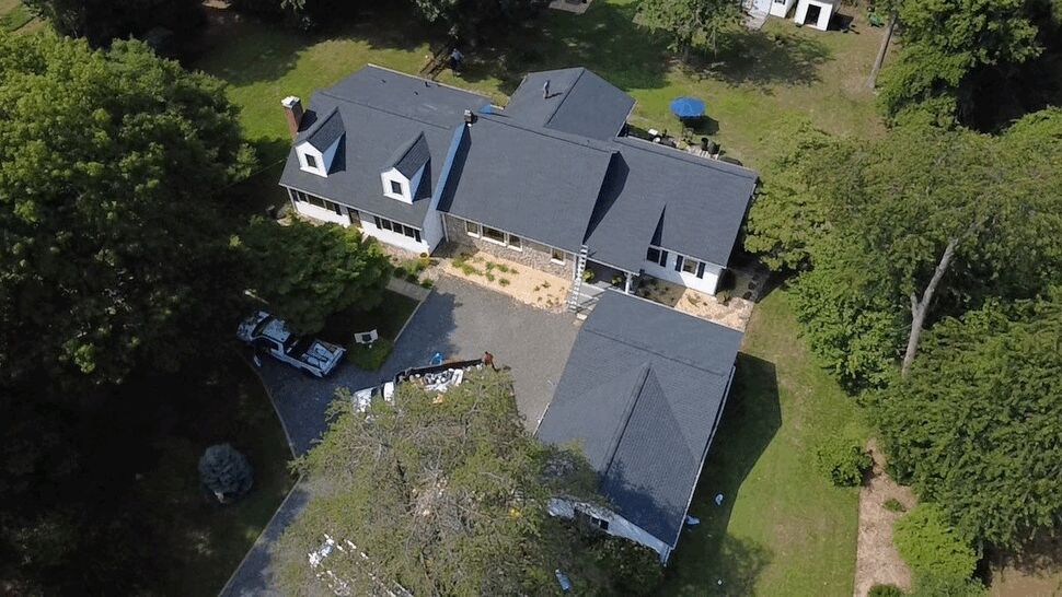 Roof Installation from Drone View | Wells Home Improvements Drone shot showing roof work with trucks and materials staged in the driveway