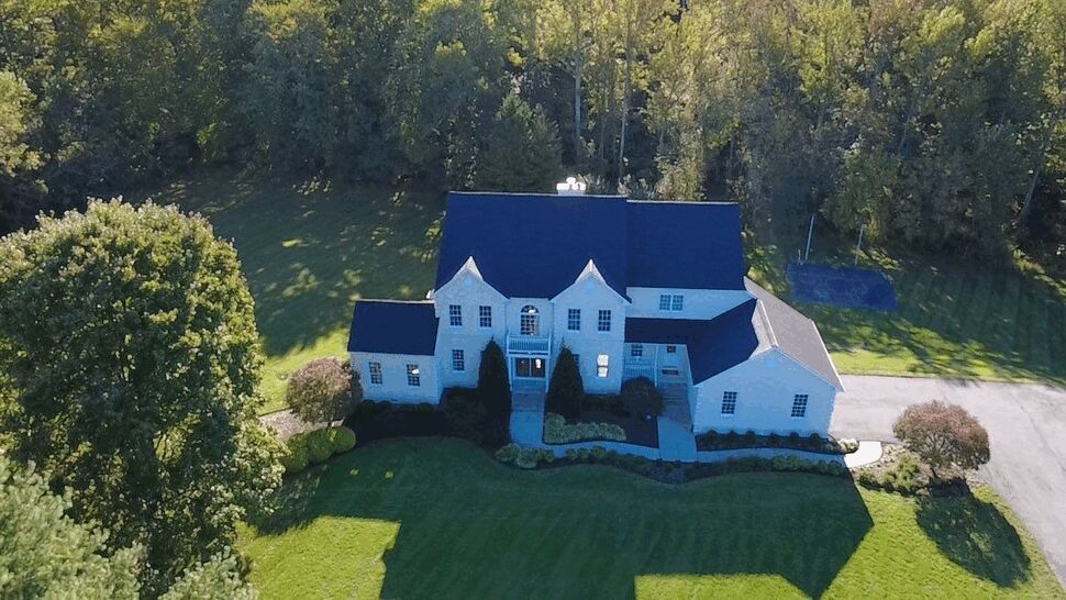 Front Home Roofing View | Wells Home Improvements Front aerial view of a white home with multiple dark roof sections.