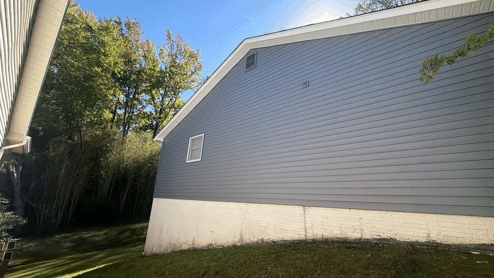 Gray Gable Wall Siding | Wells Home Improvements Gray vinyl siding on a gable wall above a light masonry foundation.