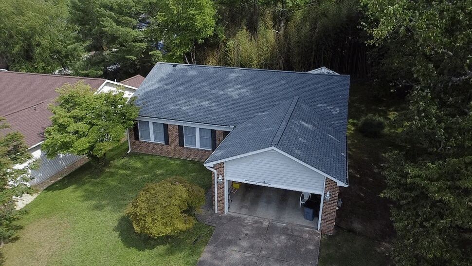 Gray Shingle Roof and Brick Home | Wells Home Improvements Gray shingle roof on a brick home with an attached garage and landscaped yard.