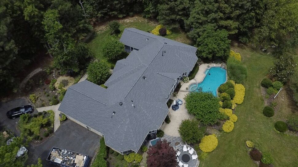 Poolside Roof Aerial | Wells Home Improvements Overhead view of a gray roof, swimming pool, and landscaped yard.