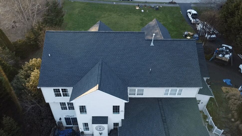Rear Main Roof Aerial | Wells Home Improvements Top-down view of the rear main roof of a large suburban home with new shingles.