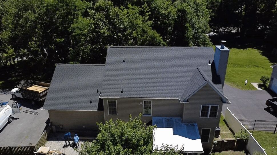 Rear roof and chimney detail | Wells Home Improvements Rear roof and chimney with dark shingles and roof vents visible