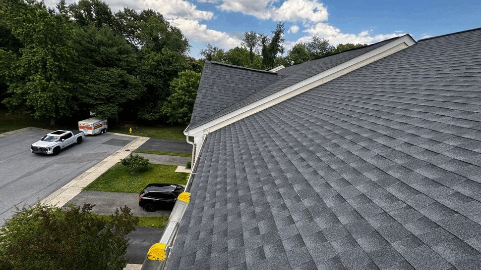 Seamless gutter installation along roofline | Wells Home Improvements Roof edge showing newly installed gutters and a ladder on the roof