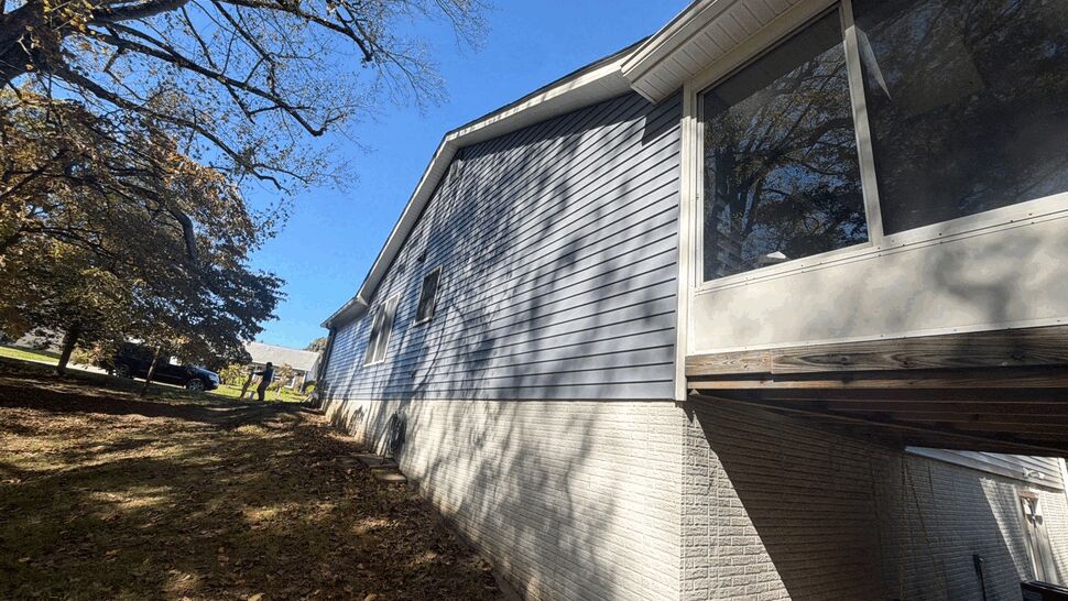 Gray vinyl siding and screened porch on a raised home exterior.