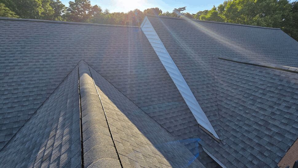 Sunlit asphalt shingle ridge on a residential roof