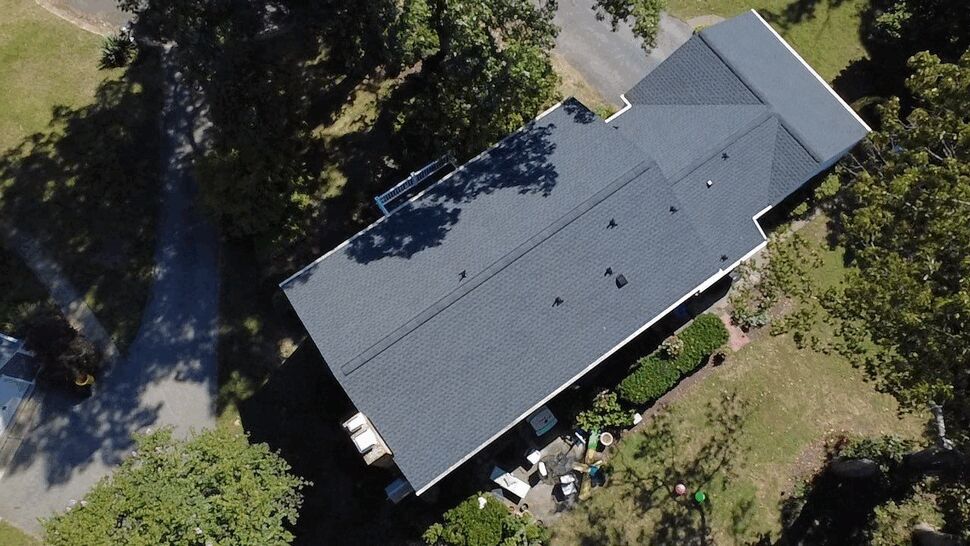Wide Roof Aerial View | Wells Home Improvements Aerial view of a large gray roof with multiple sections and roof vents.