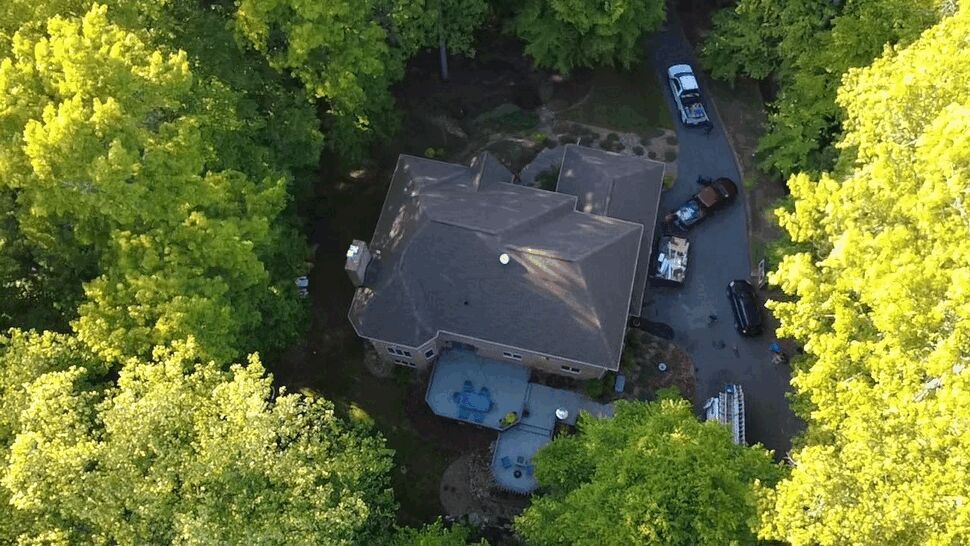 Wooded House Roof Overview | Wells Home Improvements Overhead view of a multi-section roof surrounded by mature trees.